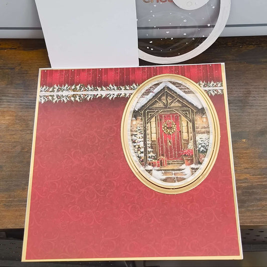 Inside view of handmade Christmas card design, showing red patterned background with oval cut-out featuring red door.