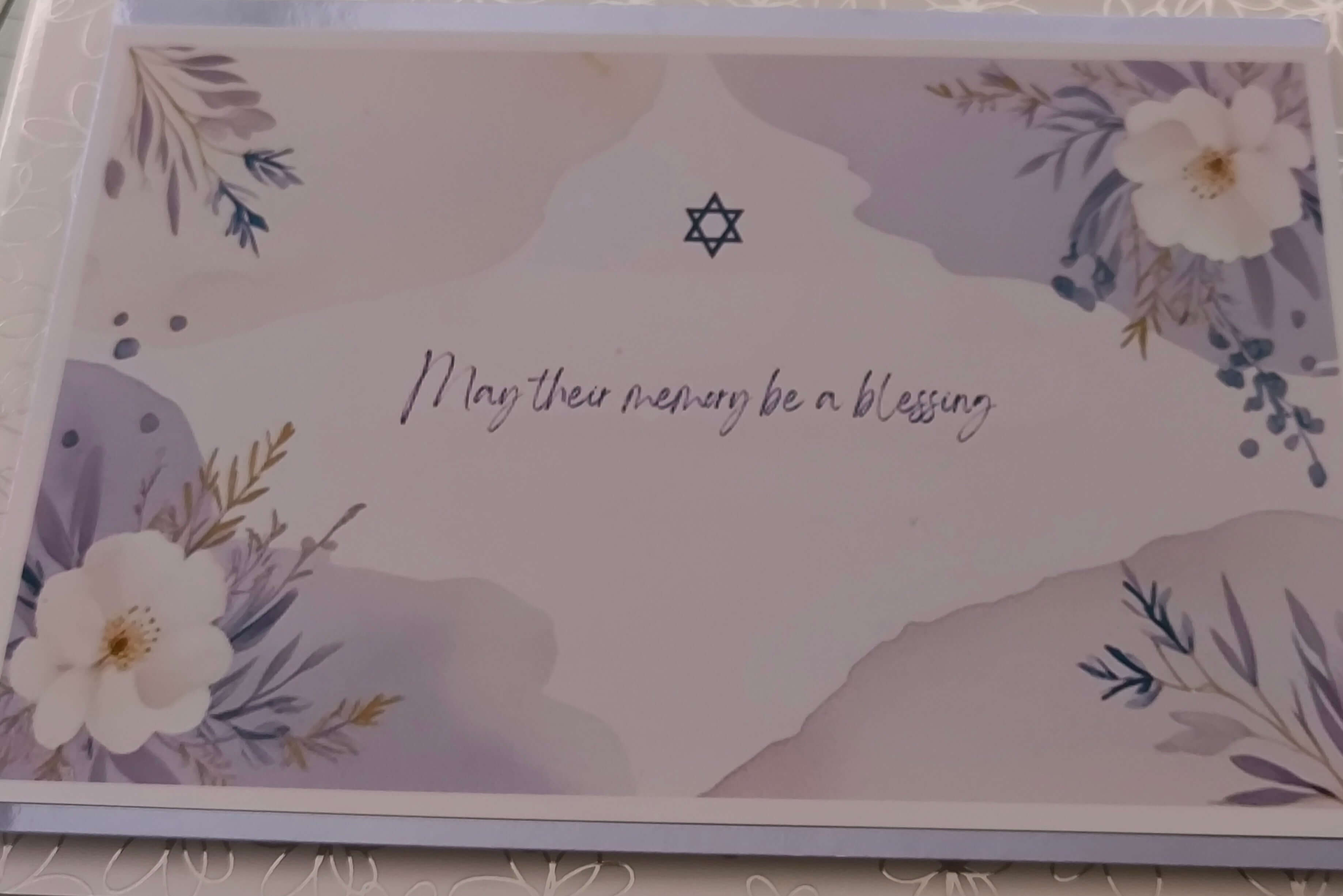 Jewish bereavement card with Star of David and floral design, featuring the message 'May their memory be a blessing' in handwritten script