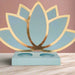 Front-facing image of a pastel blue and gold Diwali lotus sweet holder made from layered cardstock, placed on a marble surface with a soft blush pink background.