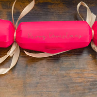 Personalised red Christmas cracker with gold ribbon and 'Merry Christmas' written on it.