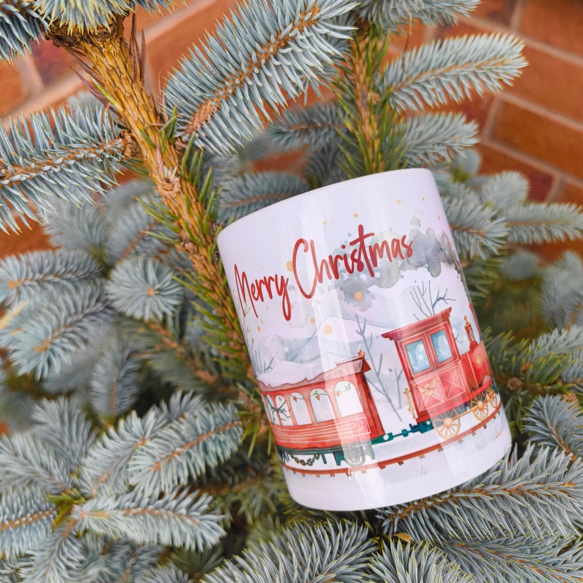 Festive Merry Christmas steam train mug hanging on evergreen tree