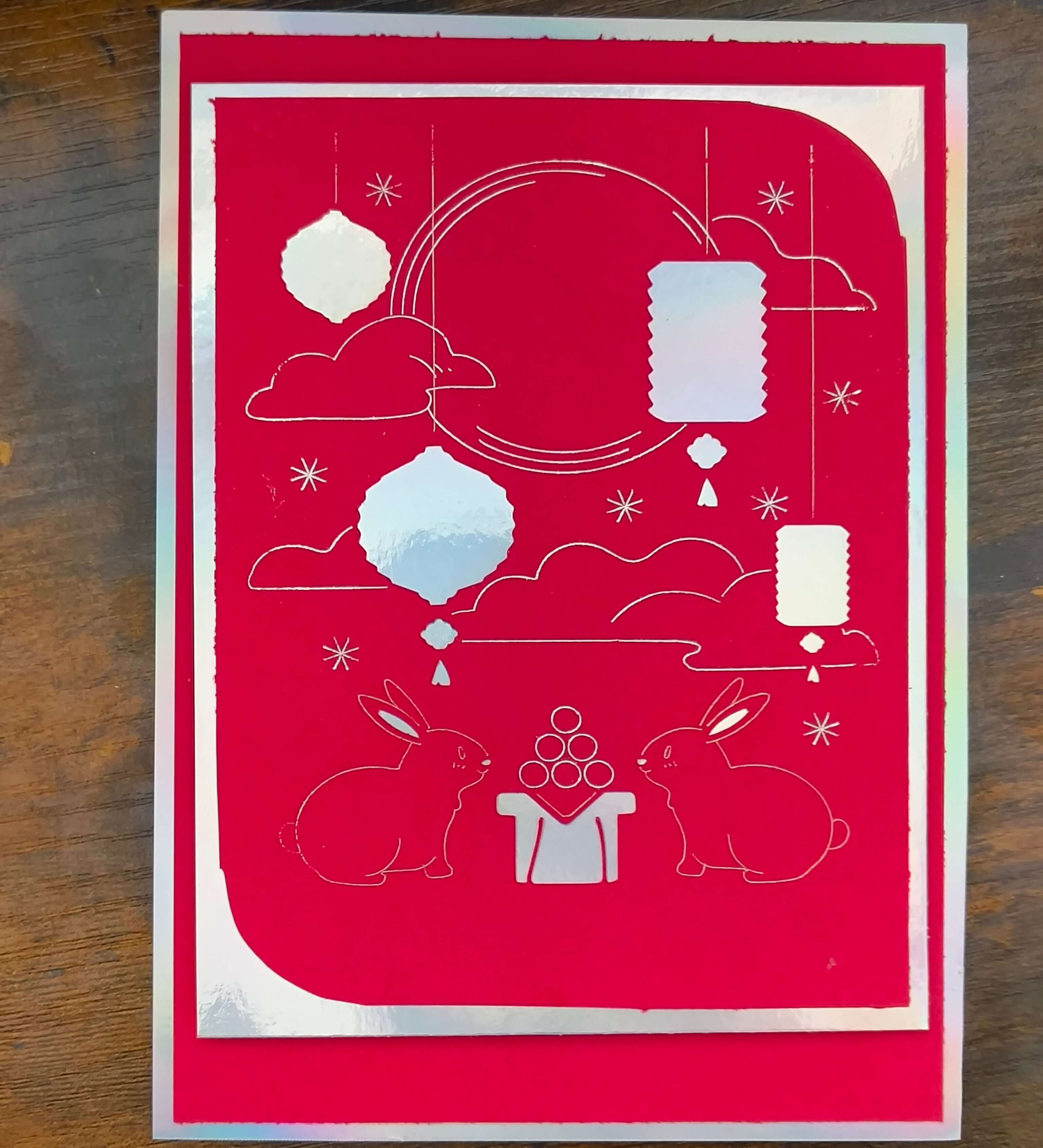 Handmade Mid-Autumn Festival card in red foil featuring moon rabbits, lanterns, and celestial designs.