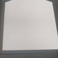 Blank folded card with a unique pentagon shape, placed on a textured black surface.