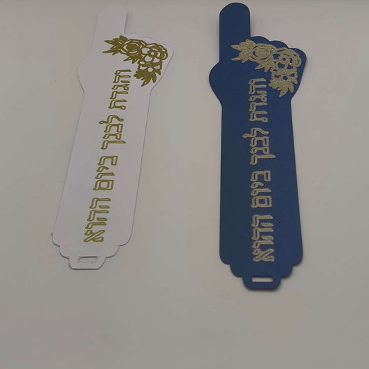 Handmade Passover bookmarks featuring Hebrew verse and intricate foil detail in white and navy blue.