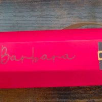 Personalized red Christmas cracker with gold ribbon and name 'Barbara' in festive handwriting.