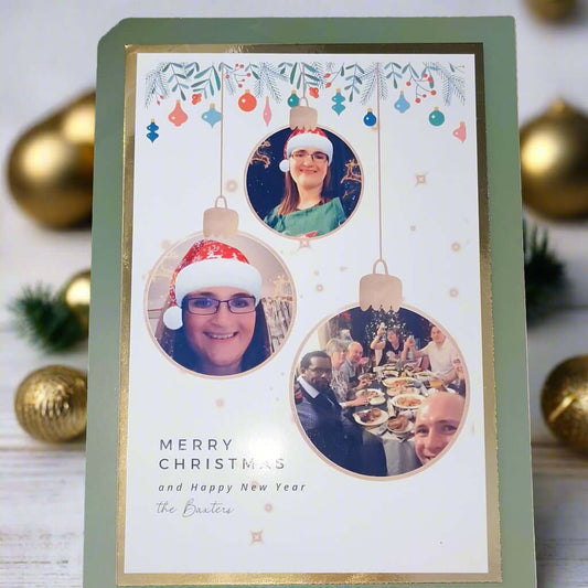 Personalised Christmas photo card – front angle – custom festive card with family photo baubles and green border.