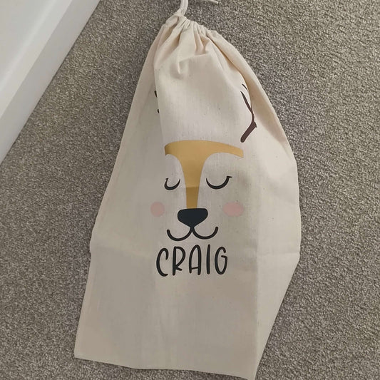 Personalised reindeer gift sack featuring a smiling reindeer face and the name 'Craig' in bold letters.