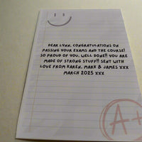 Personalised encouragement card with A+ message and custom exam congratulations text, shown from a top-side angle on a neutral background.