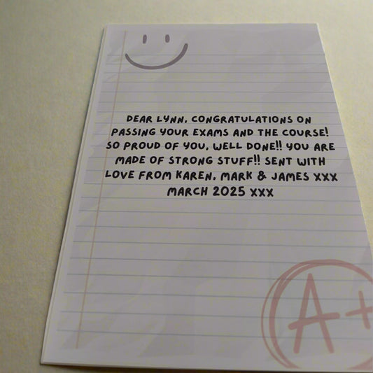 Personalised encouragement card with A+ message and custom exam congratulations text, shown from a top-side angle on a neutral background.