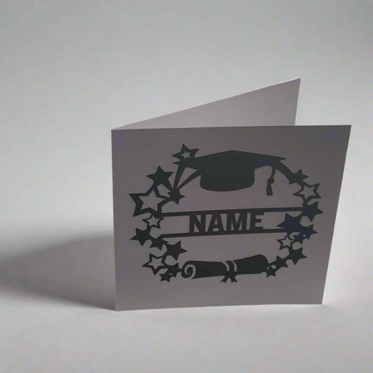 Personalised graduation card with cap, scroll, and star design, photographed from a left-side angle on a white background – handmade celebratory card.