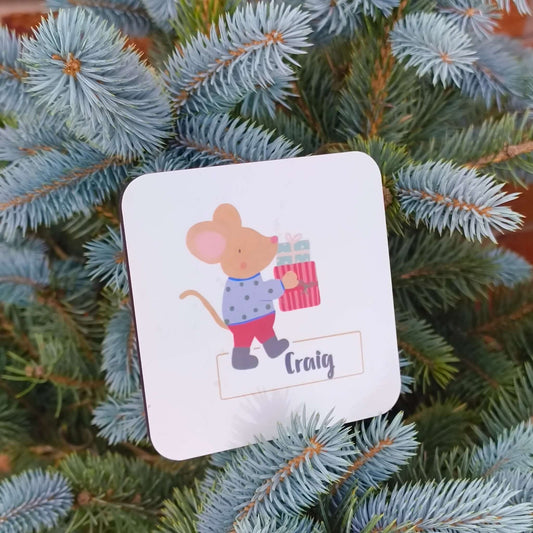 Personalised Christmas mouse coaster featuring a mouse holding a gift, customized with the name Craig.