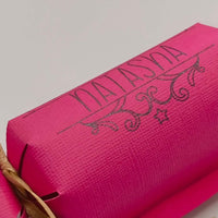 Personalised birthday crackers in vibrant pink with gold ribbon, perfect for celebrations and custom gifts.