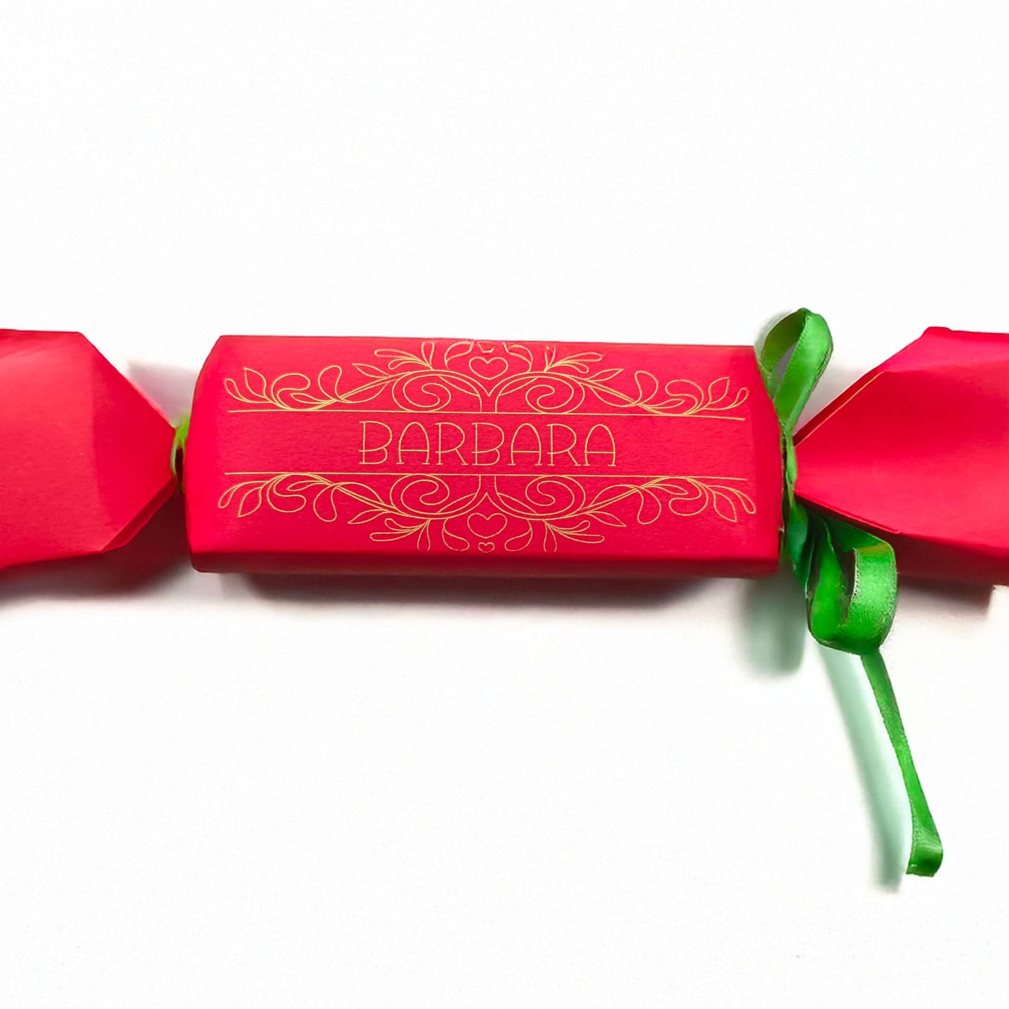 Red cracker with gold foil design and personalised name “Barbara,” finished with green ribbon, photographed on a white background for product display.