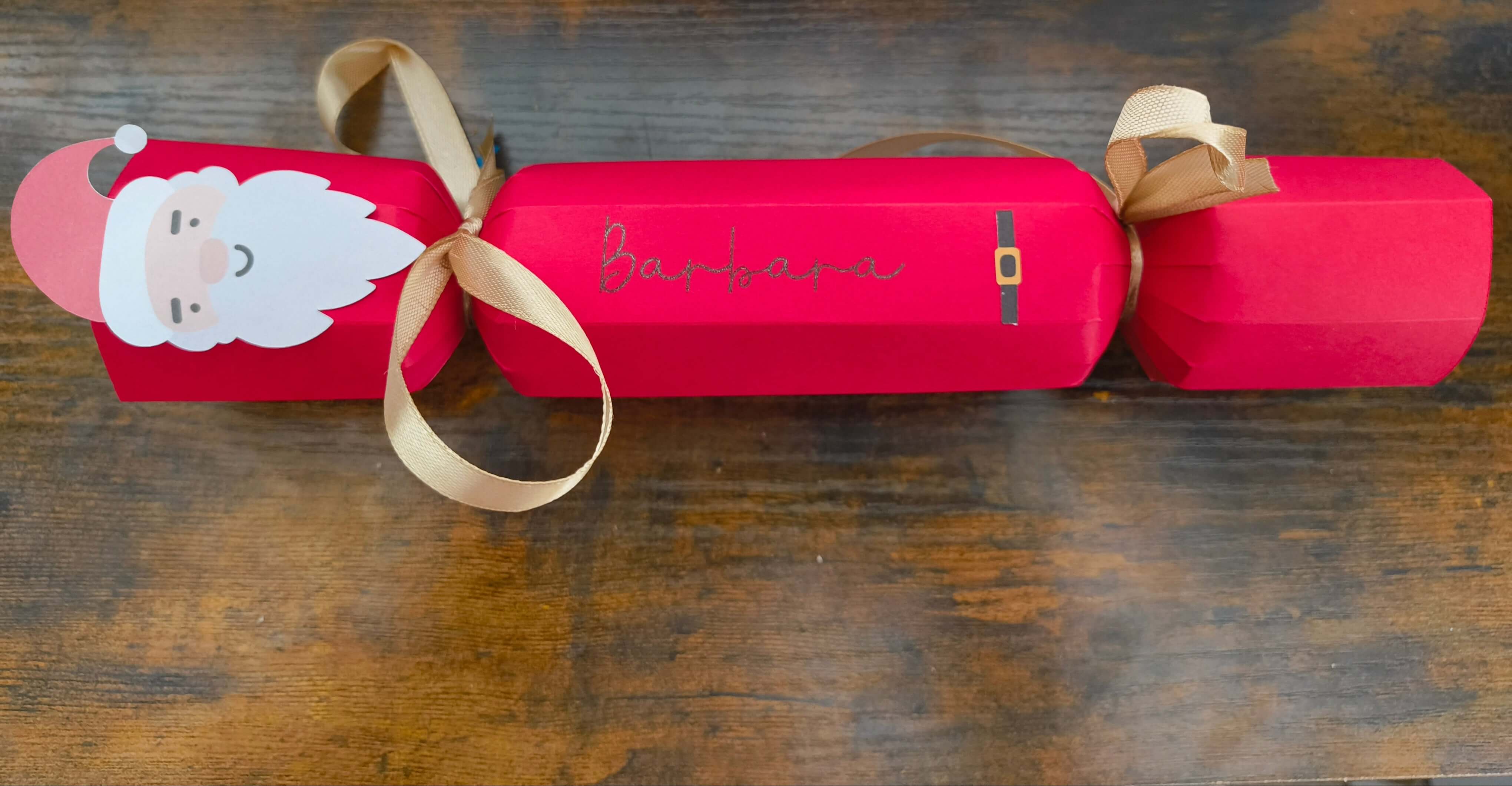 Personalised red Christmas cracker featuring a Santa design and gold ribbon, customised with the name Barbara.