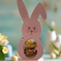 Handmade pink bunny Easter treat holder with chocolates inside, styled with pastel Easter eggs on a spring table.