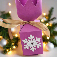 Handmade pink Christmas cracker box with snowflake design and golden ribbon, perfect for holiday gifts.
