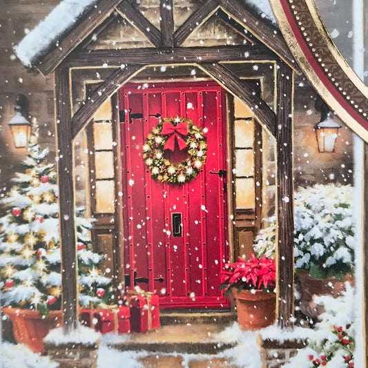 Detailed view of festive red door on handmade Christmas card with snow, wreath, poinsettias, and Christmas tree.