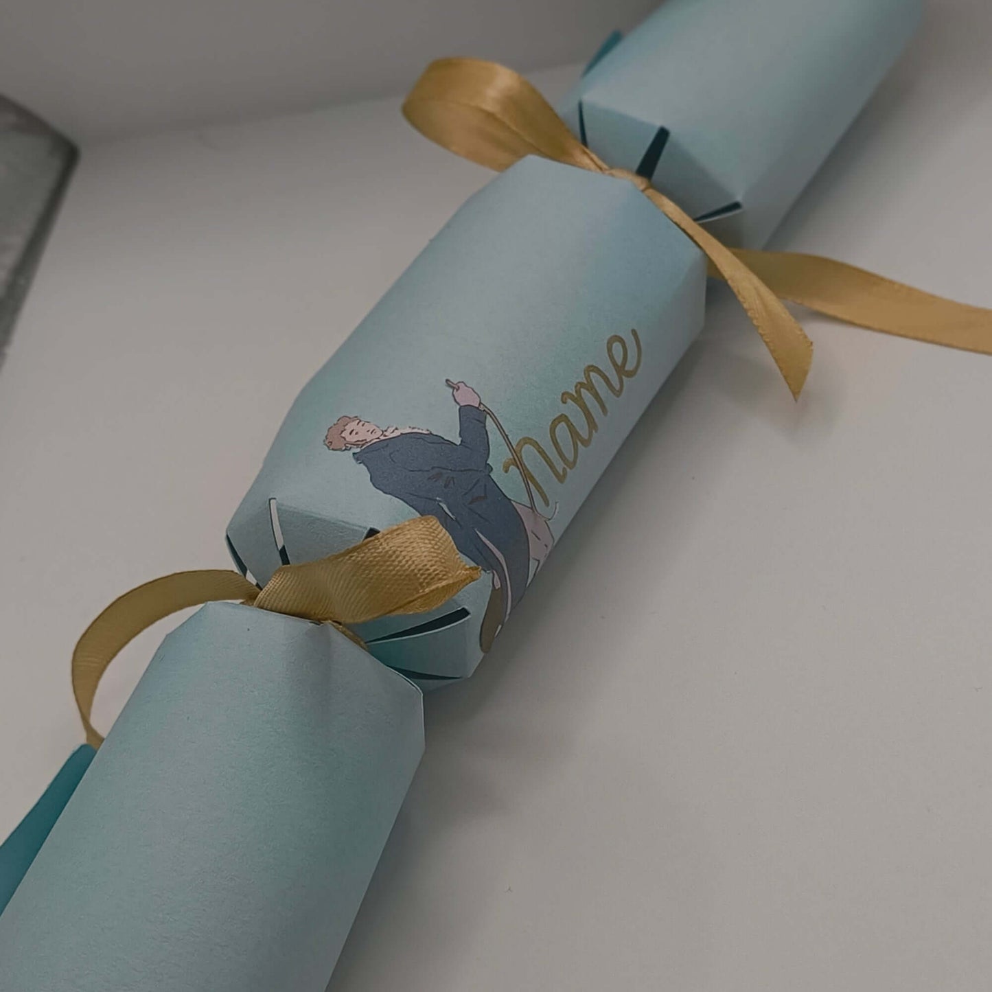 Personalised Regency Style Cracker with gold ribbon, featuring elegant character design and space for a name.
