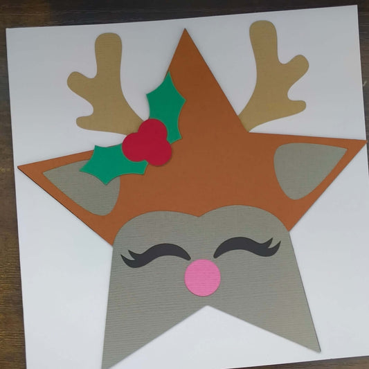 Handmade reindeer Christmas card featuring antlers, holly, and a pink nose in a star shape.