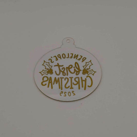 Reverse view of personalised gold and clear acrylic first Christmas bauble showing text from back.