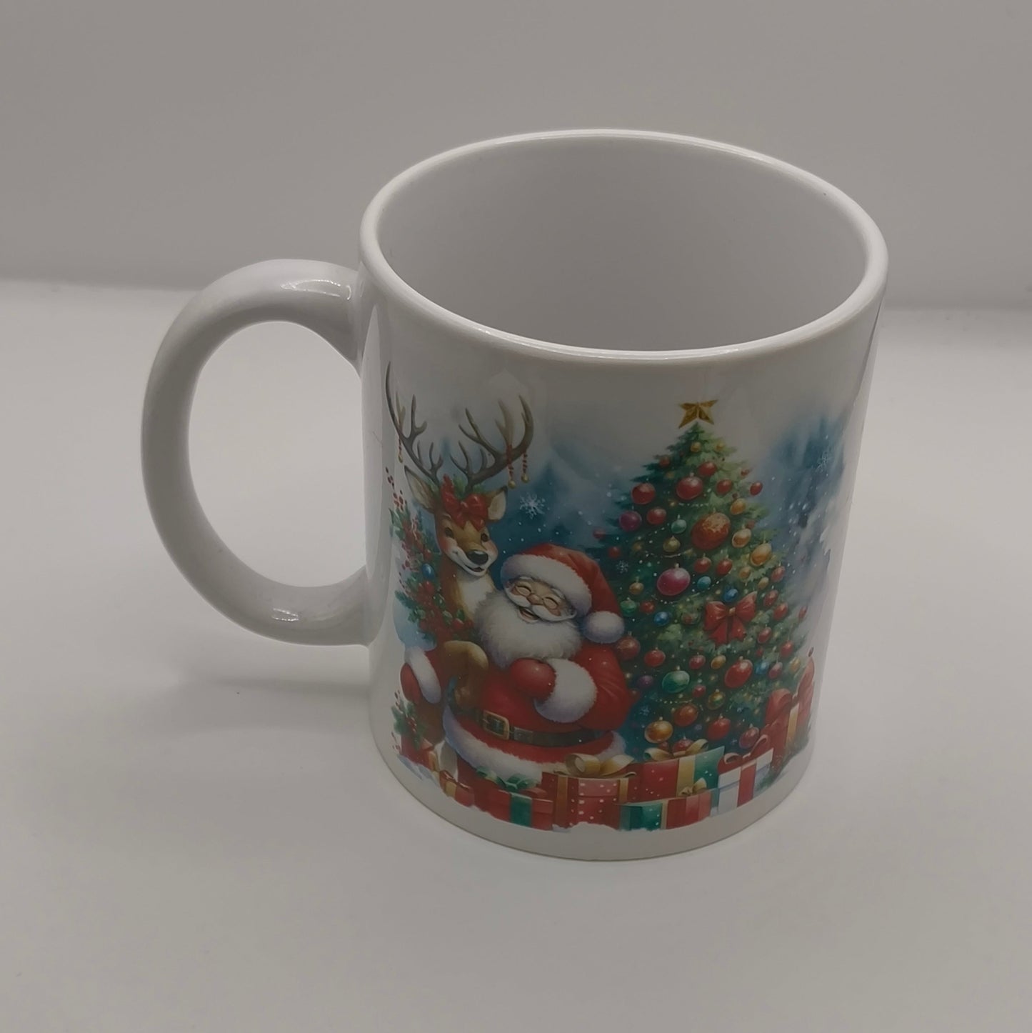White ceramic mug with Santa Claus and Christmas tree design, displayed on plain background