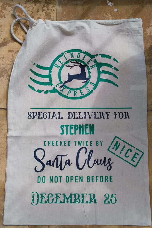Flat lay of personalised Santa Claus sack with green and black lettering, “Special Delivery” message, and December 25 note.
