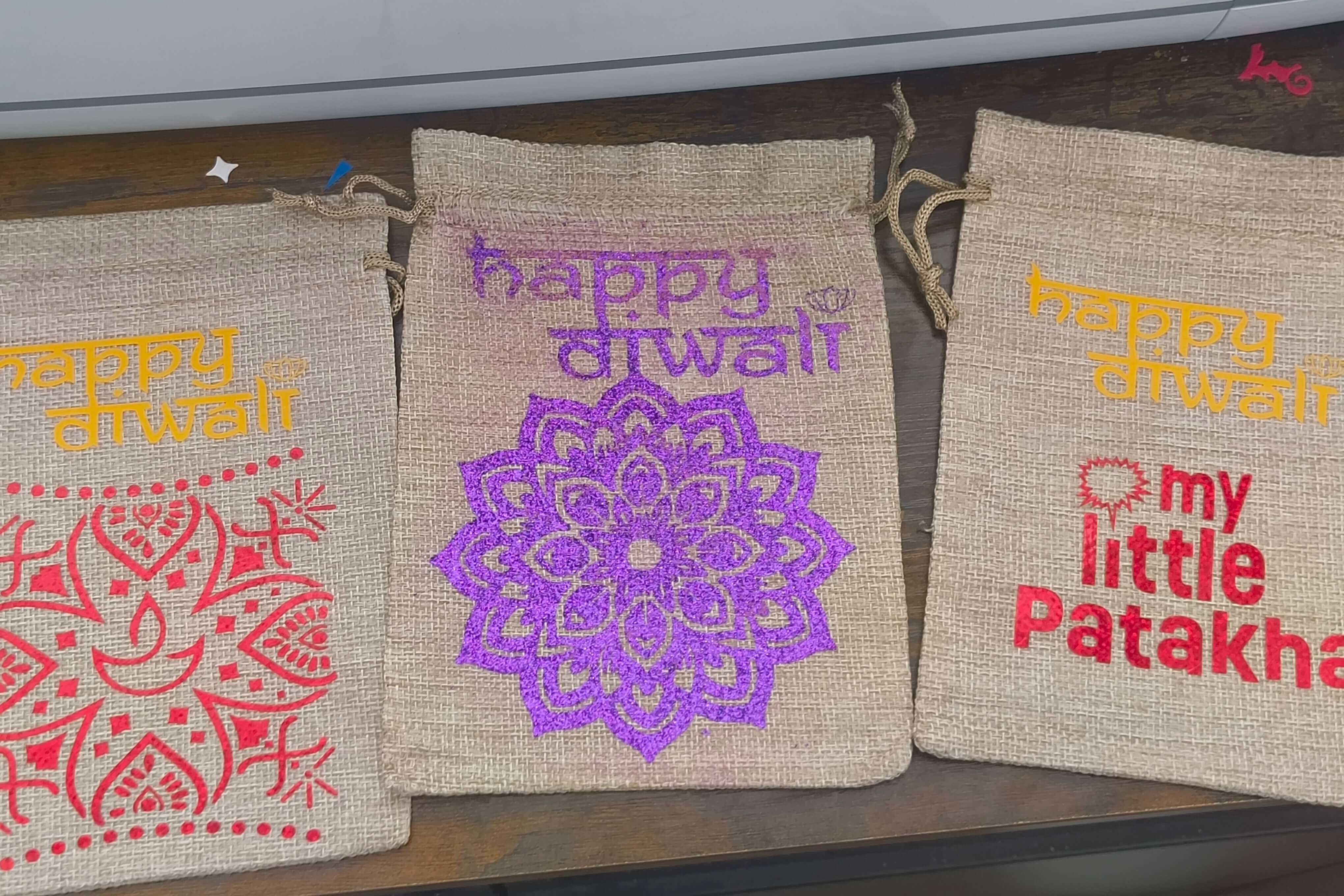 Personalised hessian bags for Diwali featuring intricate designs and festive messages. Perfect for gifts and party favours.