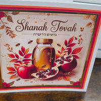 Shanah Tovah greeting card featuring apples, honey jar, and pomegranate with autumn leaves.