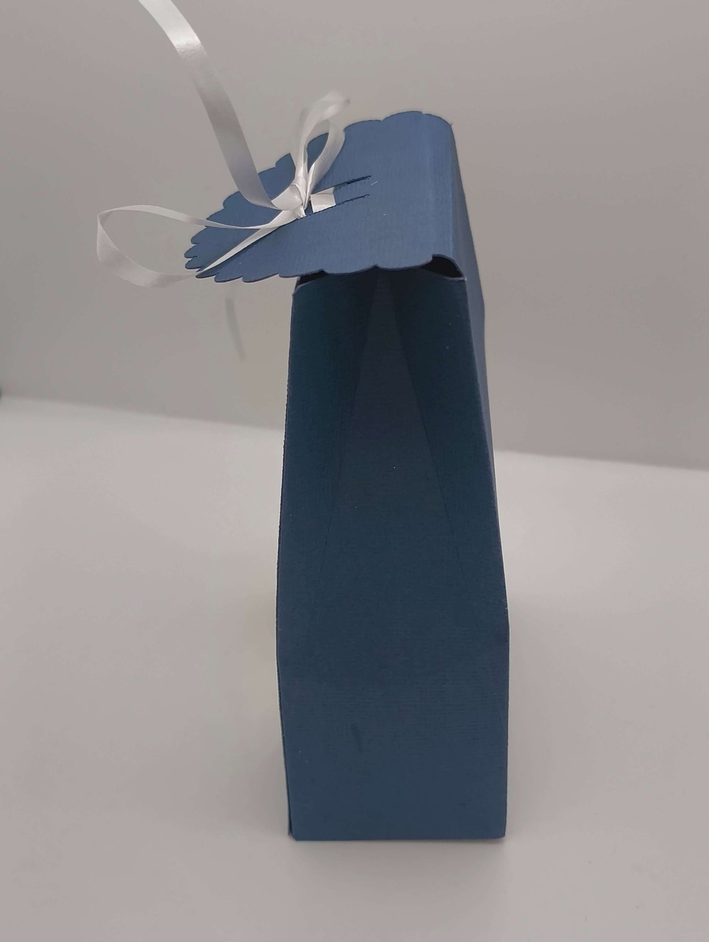 Side view of navy Ganesh gift box with scalloped lid and ribbon tie, showing handmade cardstock construction for Diwali or wedding favours.