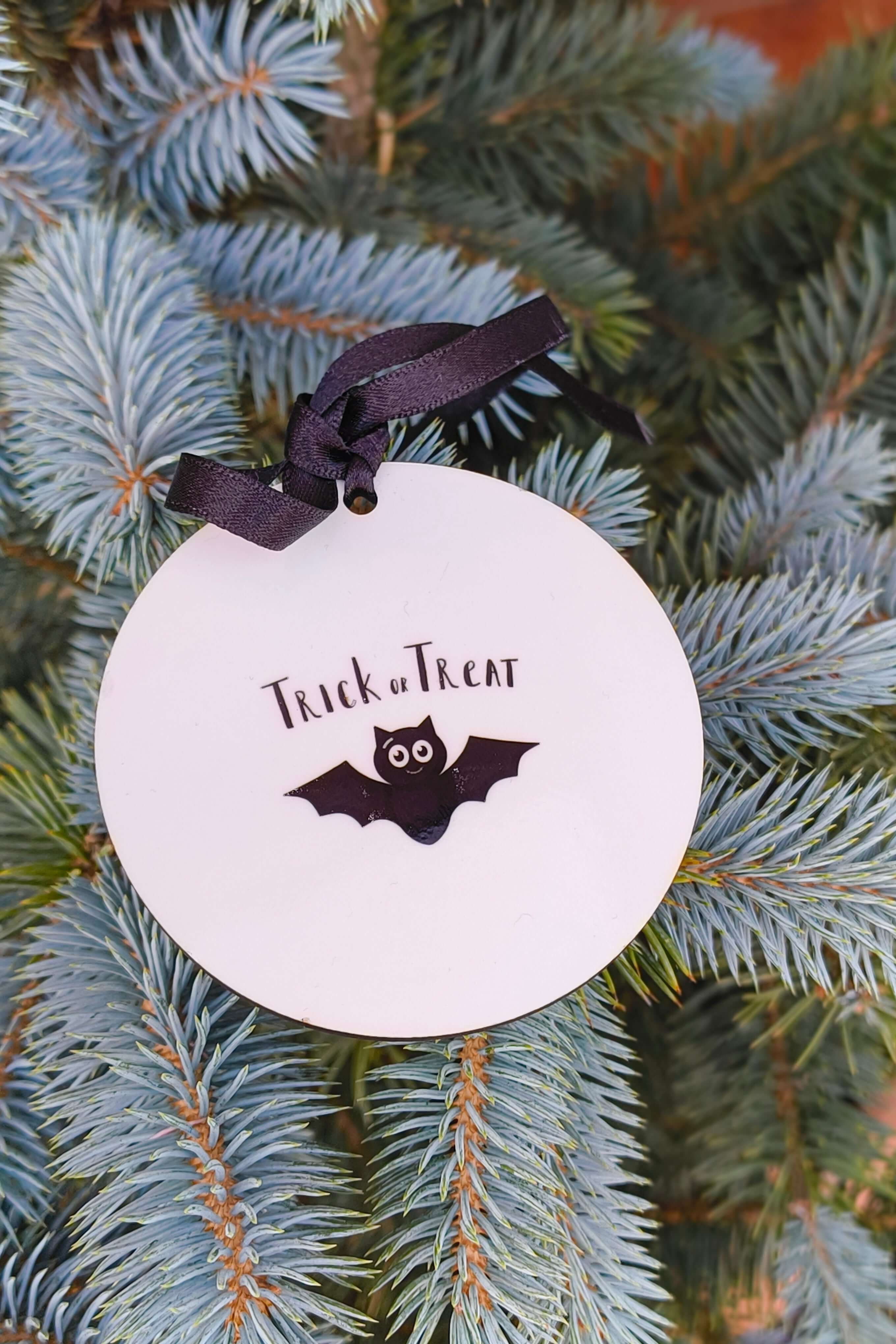 Trick or Treat bat design Halloween bauble, black ribbon hanging decoration for seasonal decor.