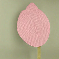 Close-up of the pink tulip flower top from the handmade cardstock place card, showing textured layered petals.