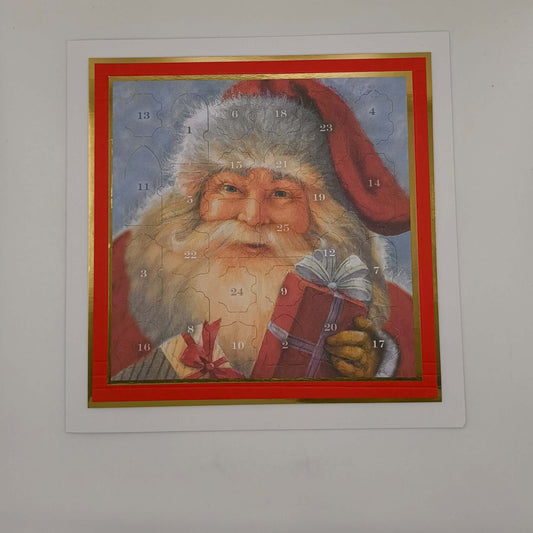 Vintage Santa Advent Calendar with numbered doors and gold border, photographed flat against a white background under bright lighting.