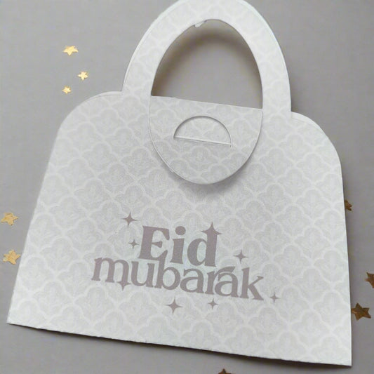 Elegant white Eid Mubarak money holder in handbag style, with delicate patterned detail and festive golden star accents.