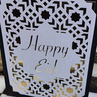 Happy Eid card featuring intricate laser cut Islamic geometric design in gold and black.