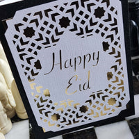 Happy Eid card featuring elegant laser cut geometric design in gold and white on a black background.
