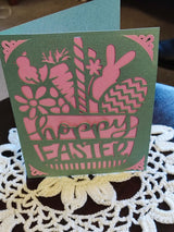 Easter greeting card featuring bunny and floral cut-outs in green and pink, with 'Happy Easter' text.