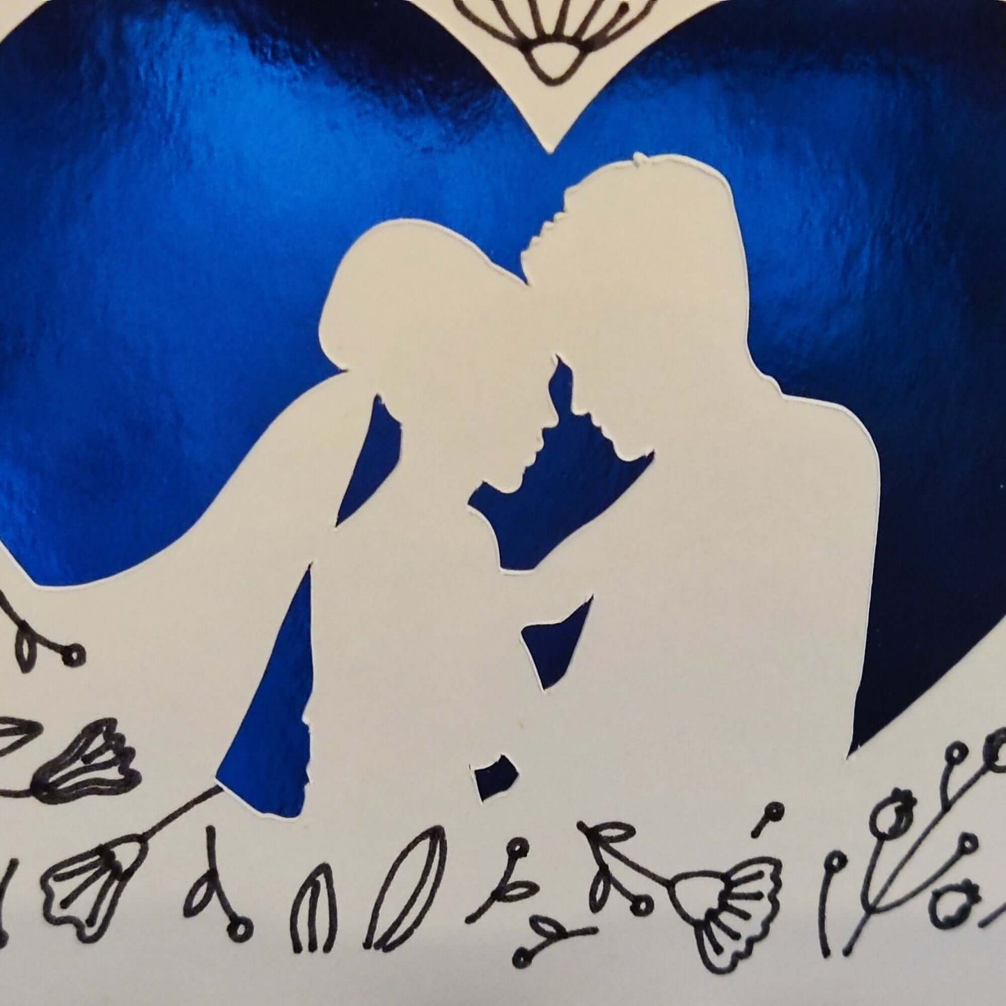 Handmade wedding congratulations card featuring a blue heart and floral design with a romantic silhouette of a couple.