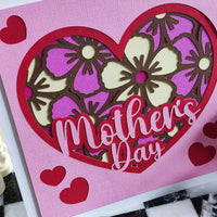 Handmade Mother's Day card with floral heart design in pink and purple, featuring layered cut-out flowers.