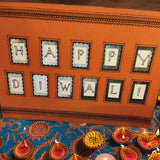 Handmade Happy Diwali card on a colourful table with traditional candles and vibrant decorations.