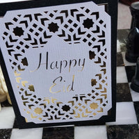 Eid card featuring a laser-cut Islamic geometric design with the message 'Happy Eid' in elegant gold lettering.