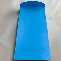 A bright blue handmade envelope with a curved flap, displayed open on a smooth cream satin-like background. The envelope is tall and narrow, ideal for festive or occasion cards.