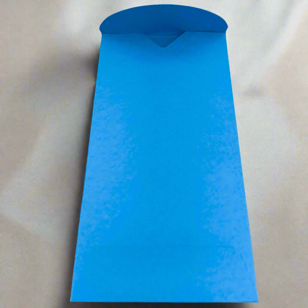 A bright blue handmade envelope with a curved flap, displayed open on a smooth cream satin-like background. The envelope is tall and narrow, ideal for festive or occasion cards.