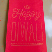 Red Diwali money envelope with gold foil-style text that reads 'Happy Diwali' in elegant lettering, placed on a soft cream and gold-toned background.