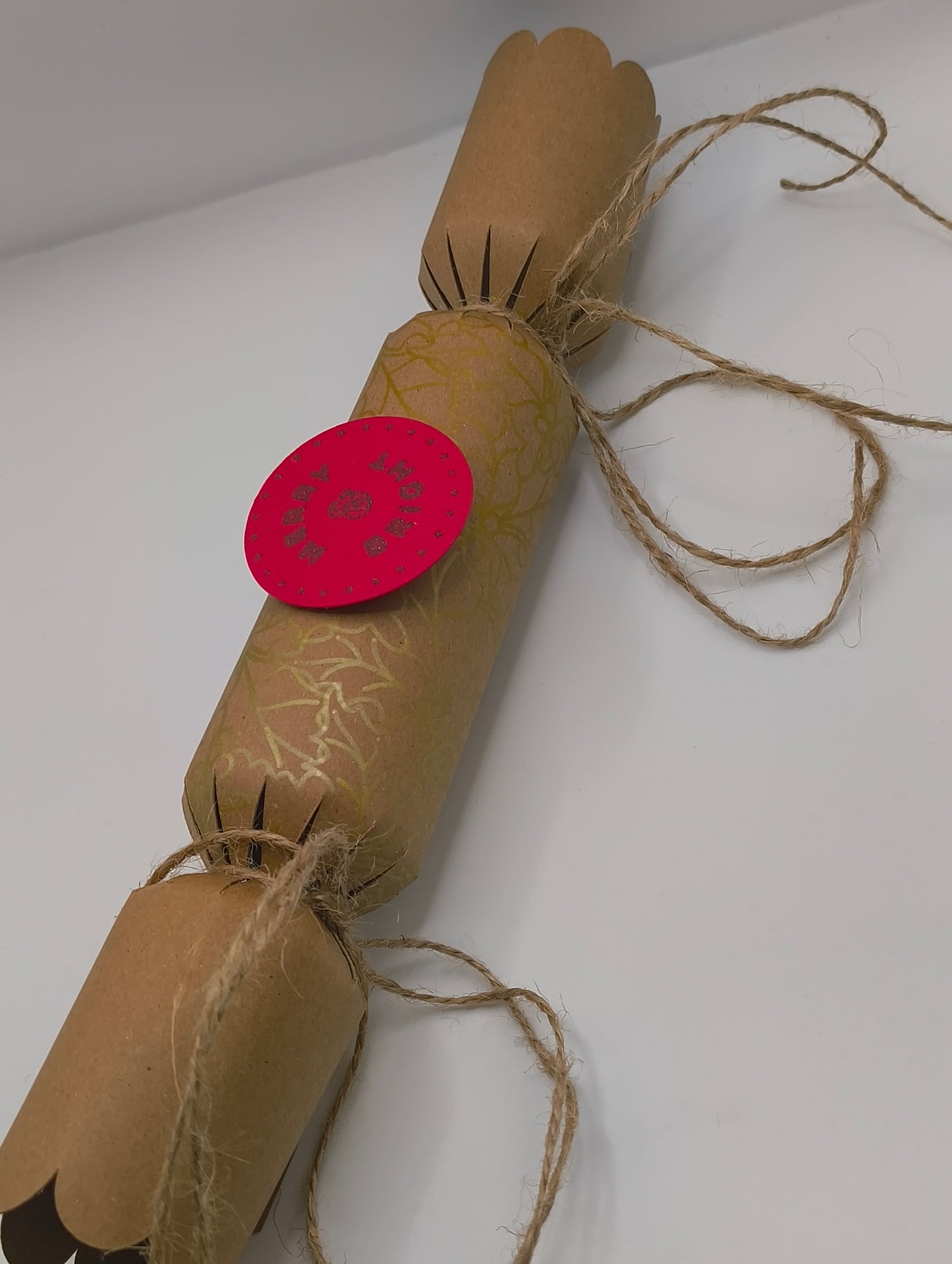 Eco-Friendly Christmas Crackers with gold holly design and jute twine for a rustic festive look.