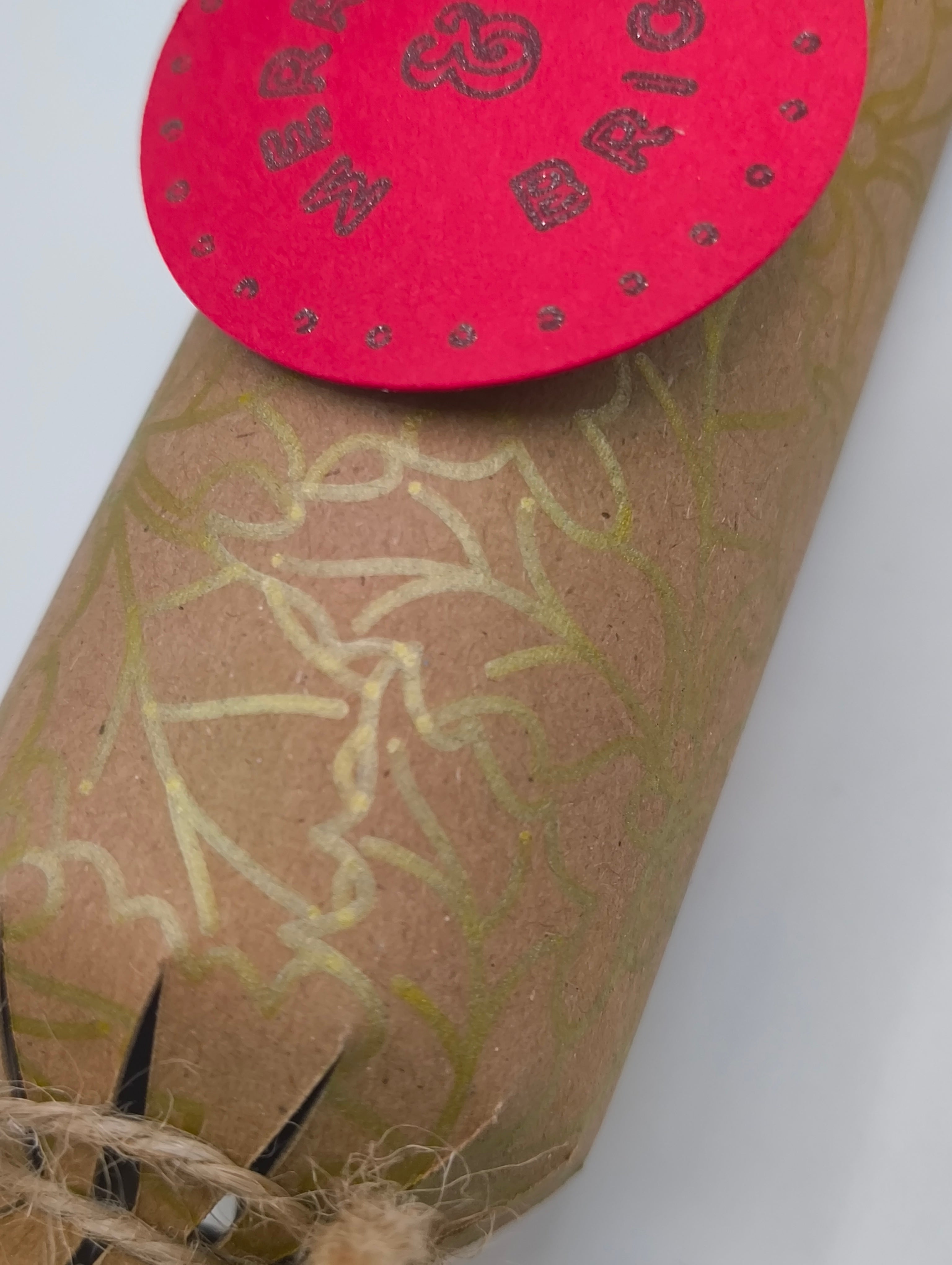 Eco-friendly Christmas crackers with gold holly design and rustic jute twine, perfect for festive celebrations.