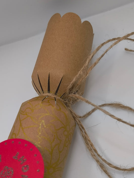 Eco-friendly Christmas crackers with gold holly design and jute twine, rustic festive style.