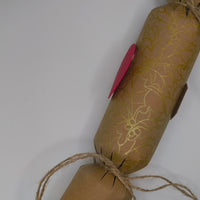 Eco-friendly Christmas crackers with gold holly design and natural jute twine for a rustic festive look.