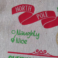 Close-up of a North Pole Santa delivery sack showcasing 'Naughty & Nice' list and festive design.