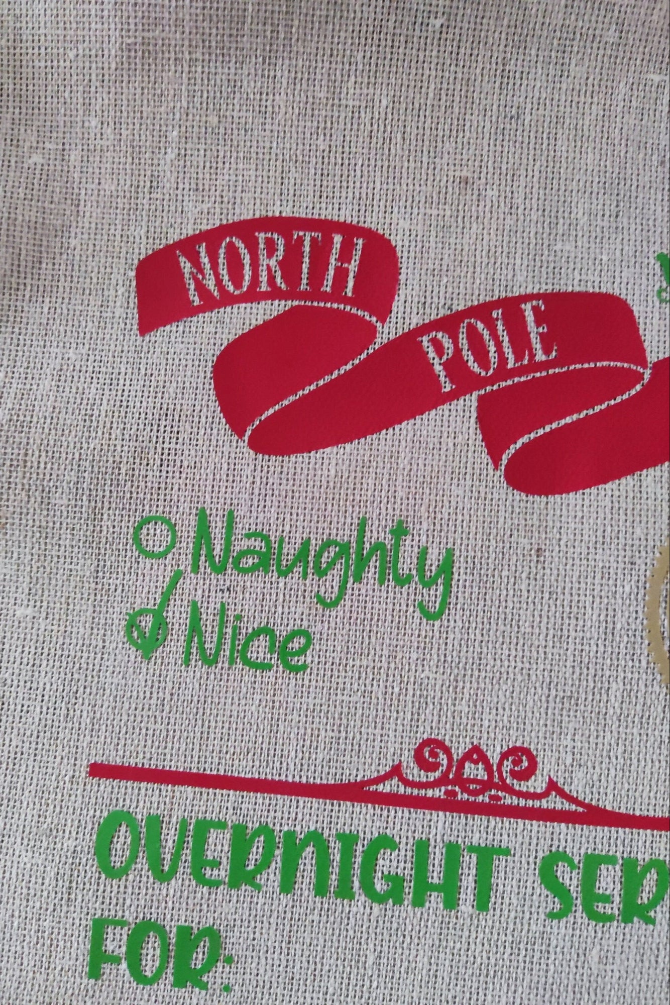 Close-up of a North Pole Santa delivery sack showcasing 'Naughty & Nice' list and festive design.