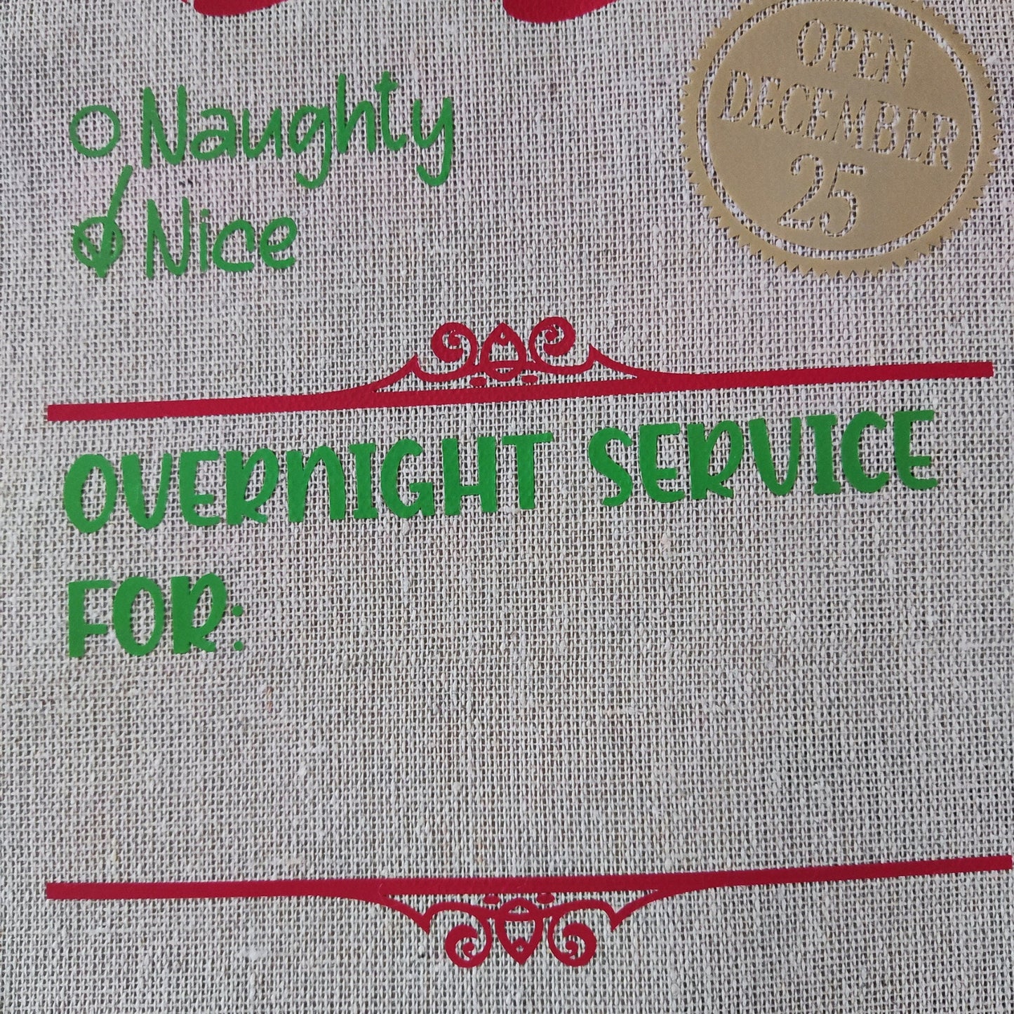 Close-up of a Christmas bag with "North Pole Post", "Naughty & Nice", "Open December 25", and "Overnight Service For" text.


